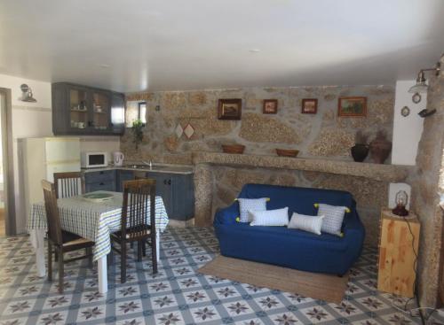 ein Wohnzimmer mit einem blauen Sofa und einem Tisch in der Unterkunft Casa da Rosa Linda in Orca
