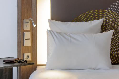 a bedroom with a bed with white pillows at Novotel Hannover in Hannover