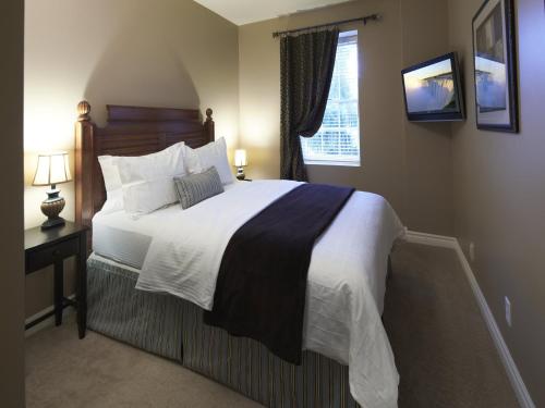 um quarto com uma cama grande e uma janela em Greaves Sweet Escape em Niagara-on-the-Lake