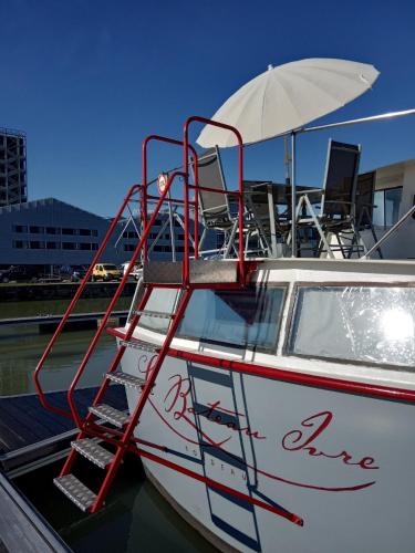 a boat with chairs and an umbrella on it at Le Bateau Ivre in Bordeaux