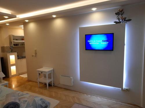 a living room with a television on a wall at Apartman Markos in Vrnjačka Banja