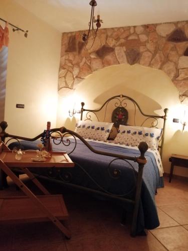 a bedroom with a large bed with a stone wall at Relax, mare, natura e cavalli Giuliano di Roma in Giuliano di Roma