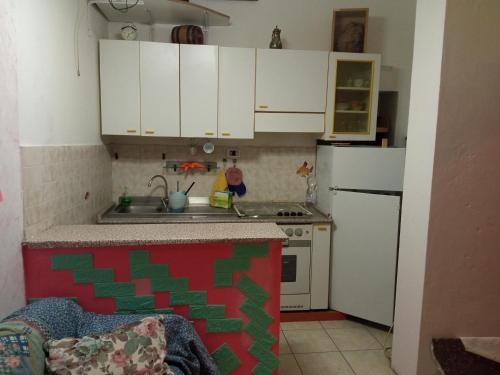 Elle comprend une petite cuisine avec des placards blancs et un évier. dans l'établissement Casa Garage, à Roccatederighi