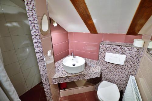 un bagno rosa con lavandino e WC di Willa Lena a Szklarska Poręba