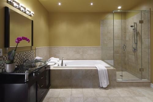 a bathroom with a tub and a shower at Greaves Sweet Escape in Niagara-on-the-Lake