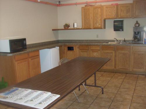 Una cocina con gabinetes de madera y una mesa de madera. en King's Inn of Platte, en Platte