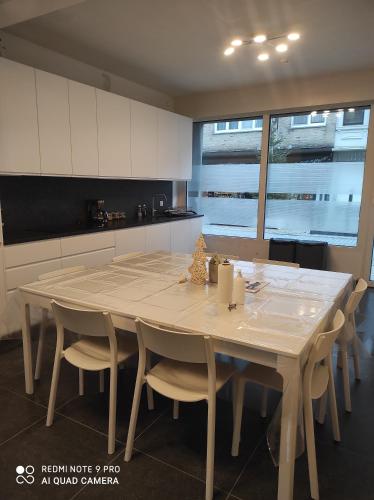 a kitchen with a large wooden table and chairs at De Zandparel in De Panne