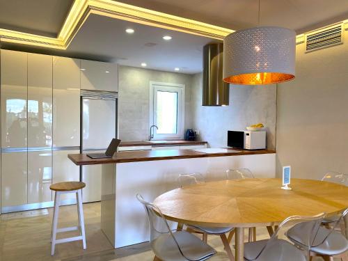 a kitchen with a table and chairs and a kitchen with a sink at Puerto Banus Jardines del Puerto Apartment for up to 6 Gardens, pools, garage, wifi, terrace in Marbella