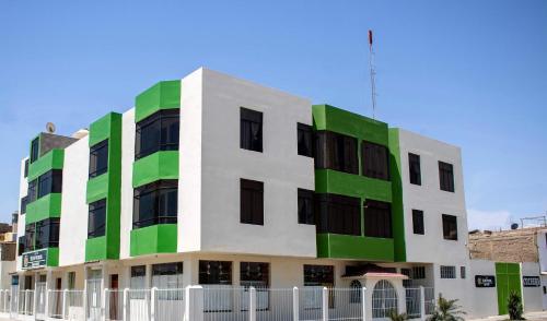 a building with green and white at Sol de Paracas Apart Hotel Pisco in Pisco