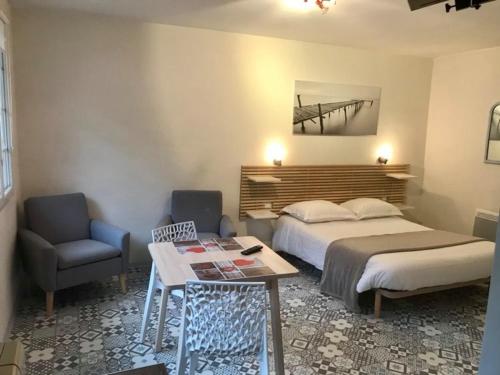 ル・トレポールにあるL'escaleのベッドルーム1室(ベッド1台、テーブル、椅子付)