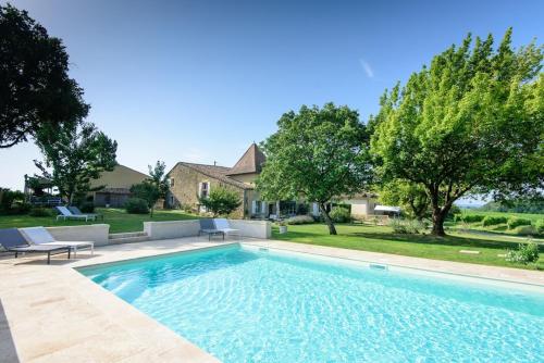 a swimming pool in front of a house at Maison des Quatre Saisons in Les Esseintes