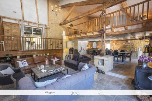 uma grande sala de estar com sofás e uma mesa em Maison des Quatre Saisons em Les Esseintes