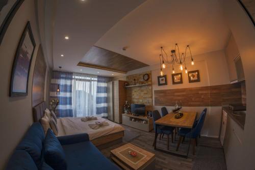 een woonkamer met een blauwe bank en een tafel bij Premier 29 Milmari Resort Wellness&Spa in Kopaonik