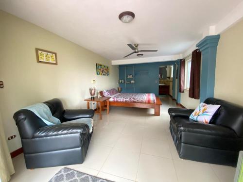 a living room with black leather furniture and a bed at Studio Pilon De Pavones in Pavones