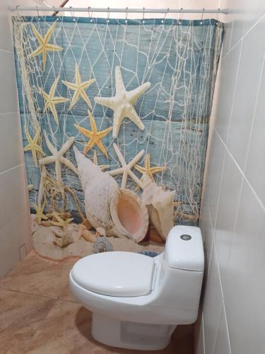 a bathroom with a toilet and a shower curtain at Atardecer porteño in Puntarenas