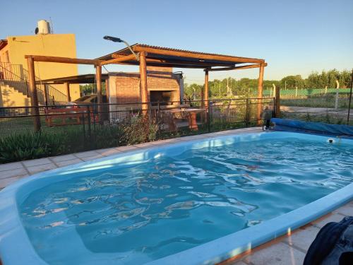 una gran piscina con agua azul en el patio trasero en Cabañas Dayma en Trapiche