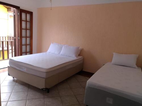 Una cama o camas en una habitación de Casa inteira no Peró, a poucos passos da praia