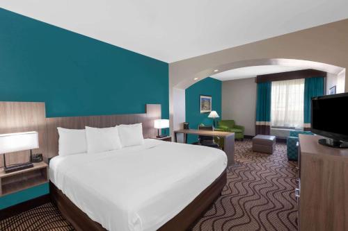 a hotel room with a bed and a television at La Quinta by Wyndham Midland North in Midland
