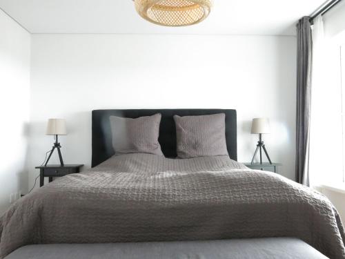 1 dormitorio con 1 cama grande y 2 lámparas en ApartmentInCopenhagen Apartment 1187 en Copenhague