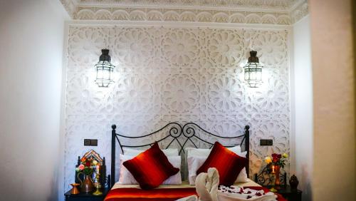 a bedroom with a bed with red pillows at Dar Habache in Marrakesh
