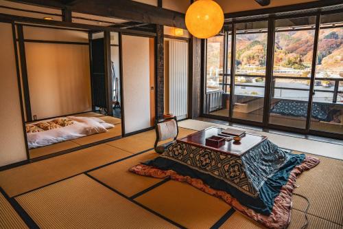 een kamer met een tafel en uitzicht op een slaapkamer bij Yamakikan in Naganohara