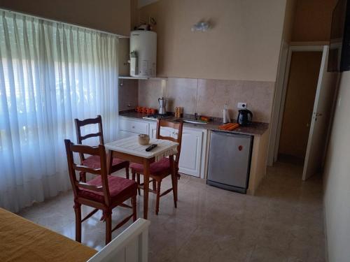 a kitchen with a table and chairs and a kitchen with a stove at Departamento Necochea in Necochea