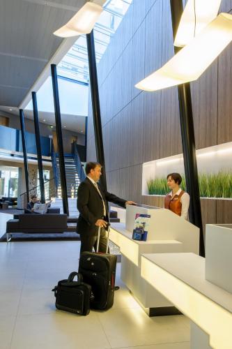 a man standing in an airport with a suitcase at Novotel Hannover in Hannover