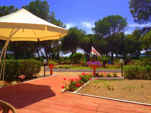 a garden area with a picnic table and chairs at Villaggio Camping Nurral in Fertilia