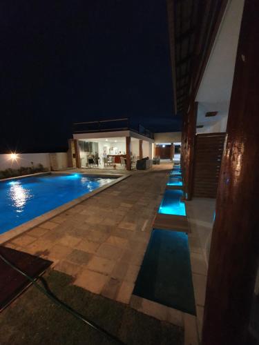 a swimming pool in a villa at night at Caly Pousada in São Miguel do Gostoso