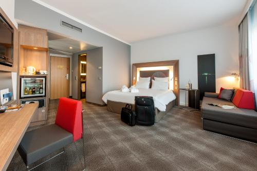 une chambre d'hôtel avec un lit et un canapé dans l'établissement Novotel Hannover, à Hanovre