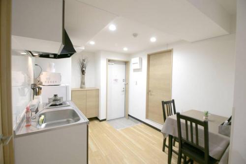 a kitchen and dining room with a sink and a table at Uhome千駄木静雅民宿旅馆 in Tokyo