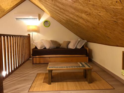 a bedroom with a bed and a table in a attic at La Case Floria in Saint-André