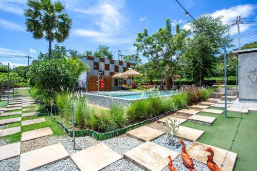 a garden with a swimming pool and a resort at บ้านมะนาวรีสอร์ท เกาะล้าน in Ko Larn