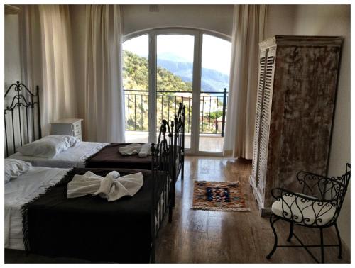 Un dormitorio con dos camas y una gran ventana. en Villa Valo, en Kalkan