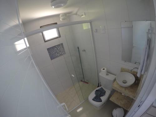 a bathroom with a shower and a toilet at Chalé 4, Maragogi, Condominio Village Galés in Maragogi