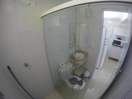 a bathroom with a glass shower and a toilet at Chalé 4, Maragogi, Condominio Village Galés in Maragogi