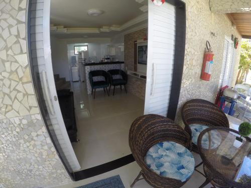 a view of a living room with chairs and a table at Chalé 4, Maragogi, Condominio Village Galés in Maragogi