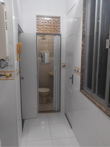 uma casa de banho com um WC e um espelho. em Quarto Leme no Rio de Janeiro