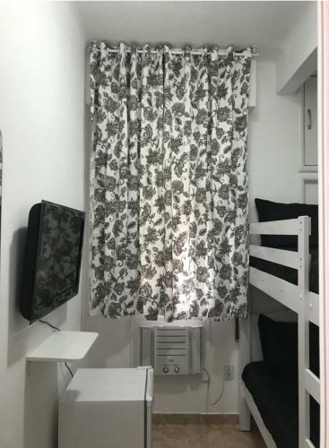 een slaapkamer met een gordijn en een stapelbed bij Quarto Leme in Rio de Janeiro