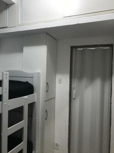 a bunk bed in a room with a ladder and a door at Quarto Leme in Rio de Janeiro