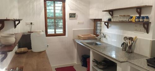 a kitchen with a sink and a counter top at Isai Ambalam guest house in Puducherry