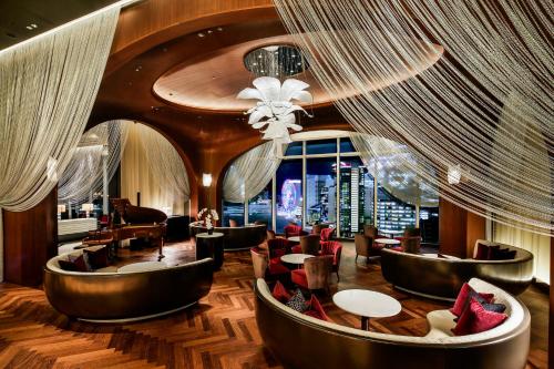 a hotel lobby with chairs and tables and a chandelier at The Kahala Hotel & Resort Yokohama in Yokohama