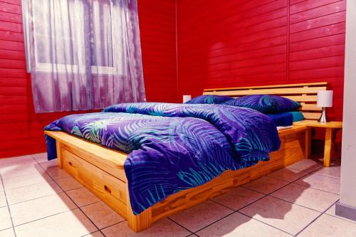 two beds in a room with red walls at Case au pied du volcan in La Plaine des Cafres