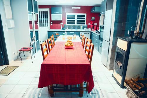 a kitchen with a red table with chairs and a stove at Case au pied du volcan in La Plaine des Cafres