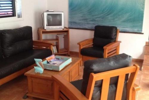 a living room with two chairs and a tv at KAKTUS BEACH House in Corralejo