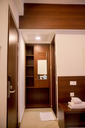 a bathroom with a wooden door and a mirror at Zoot Kochi Infopark in Cochin