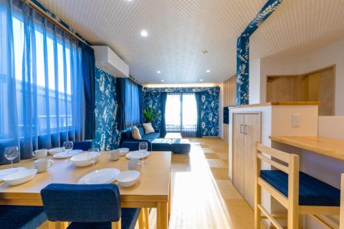 uma sala de jantar com uma mesa e cortinas azuis em 02 Resort Club -蒼SOU- em Fujikawaguchiko