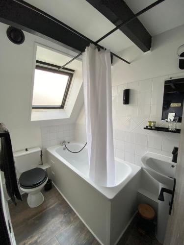 y baño con bañera, aseo y lavamanos. en La Maison Sévigné - Appart Hôtel - N°6 L'indus, en Béthune