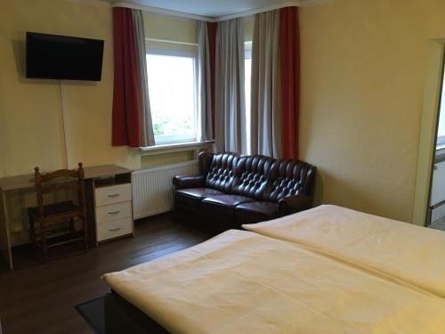 a hotel room with a bed and a couch and a chair at Hotel Sieme in Osnabrück