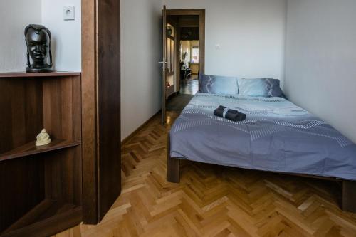 a bedroom with a bed with blue sheets and a mirror at "34" Apartment in Belgrade